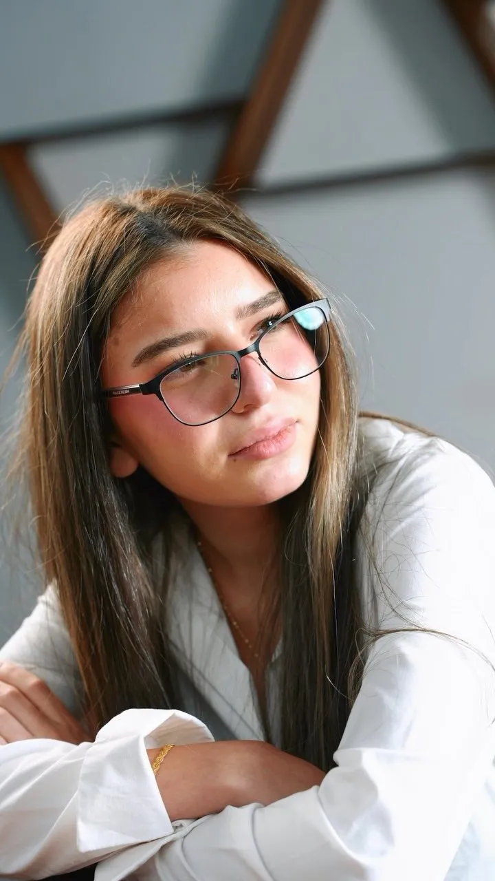 Young woman in a black cat-eye frame and a white shirt